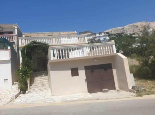 a white house with a balcony and a garage at Tonica Put rive 17 in Metajna