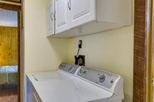 eine Waschmaschine in einer Waschküche mit weißen Schränken in der Unterkunft Alpine Lake Resort Cabin Rental with Pool Access! in Terra Alta