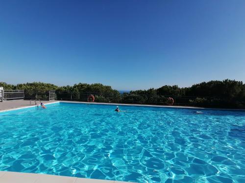 una gran piscina azul con gente en ella en La Sundevilla, en Bergeggi