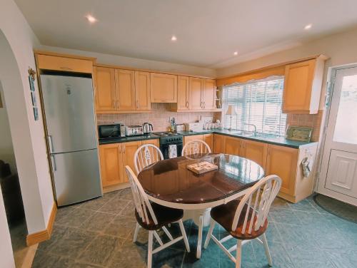 a kitchen with a table and chairs and a refrigerator at Tower View Lodge in Ennis