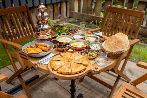 a wooden table with food and bread on it at Safir Doğa Evleri in Rize