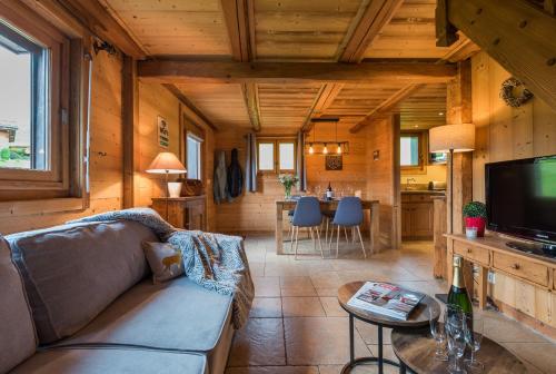 a living room with a couch and a tv in a cabin at Le Mazot de Janton in Combloux