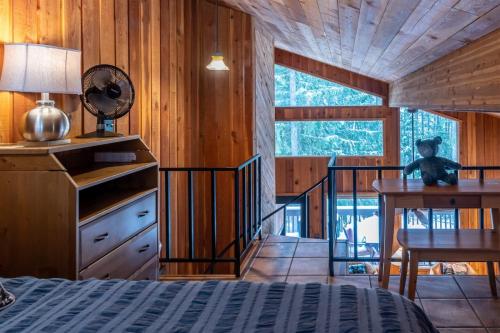 a bedroom with a bed and a desk and a staircase at Escape To Ptarmigan Village 100 in Whitefish