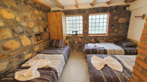 a room with two beds and a stone wall at Villa Old House BN in Bitola