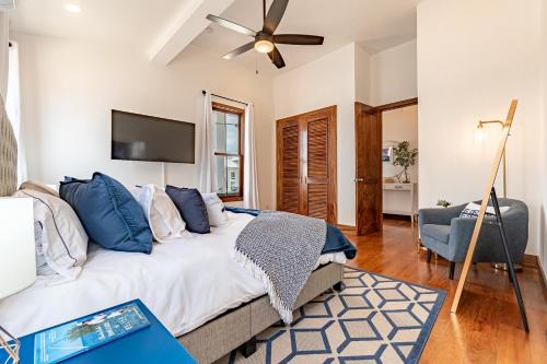 a bedroom with a large bed with a ceiling fan at The Weekender and The PoolClub at Mahogany Bay! in San Pedro