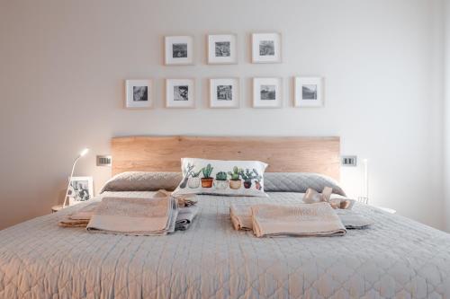 een slaapkamer met een groot bed met foto's aan de muur bij Una Chicca in Valdobbiadene