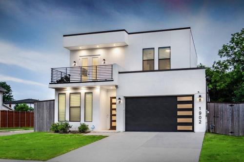 a white house with a garage at Glam Paradise 5BRs Downtown Dallas in Dallas
