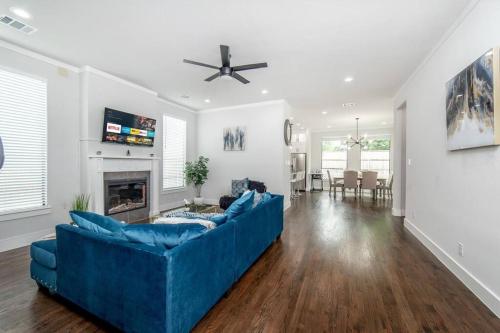 a living room with a blue couch and a fireplace at Glam Paradise 5BRs Downtown Dallas in Dallas