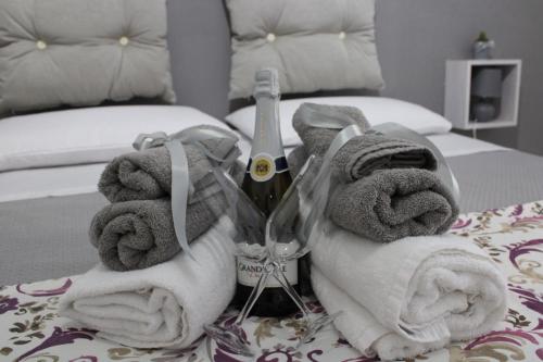 - une chambre avec un lit, des serviettes et une bouteille de vin dans l'établissement Rosaria's Home, à Brindisi