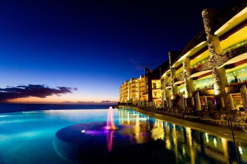 a city street with a fountain in the water at night at Gloria Palace Royal Hotel & Spa in Puerto Rico de Gran Canaria