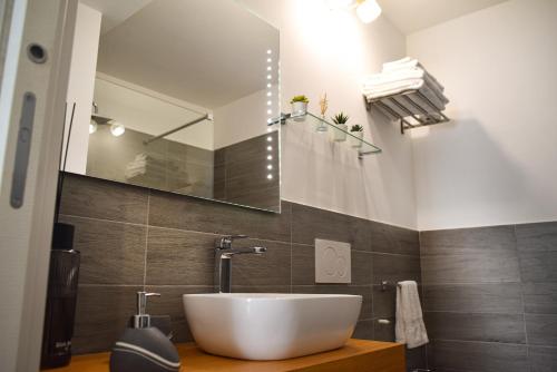 a bathroom with a white sink and a mirror at Variopinto Home in Ischia Town