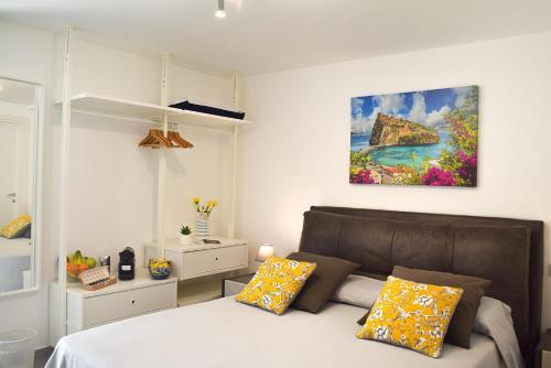 a bedroom with a bed and a painting on the wall at Variopinto Home in Ischia Town