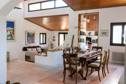 ein Esszimmer und ein Wohnzimmer mit einem Tisch und Stühlen in der Unterkunft Kouvelia Country Home Luxury Villa Rental in Nerotriviá