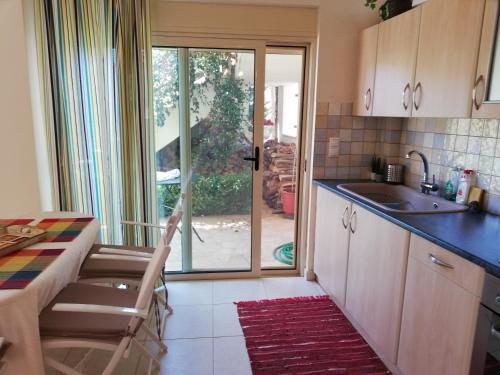 a kitchen with a table and a sink and a kitchen with a window at ALTHEA HOLIDAY STUDIO in Aghia Marina