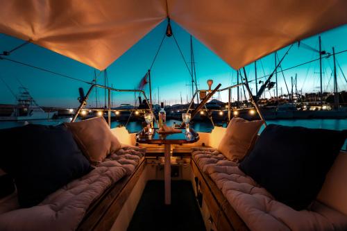 a boat with couches and a table on the deck at Seaside Chill-out Stay on a Sail Yacht in Puerto Calero