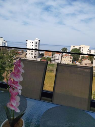 a vase of flowers sitting on a table on a balcony at Apartmani Aida in Dobra Voda