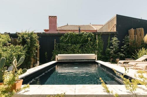 a swimming pool with a bench in a backyard at Casa da Aldeia - Baleal - Peniche in Casais Brancos