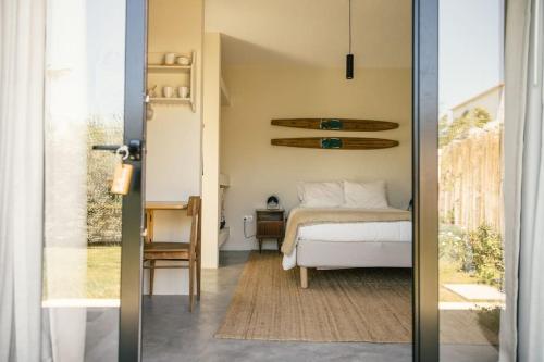 een slaapkamer met een bed en een deur naar een kamer bij Casa da Aldeia - Small House Selva - Peniche - Baleal in Casais Brancos