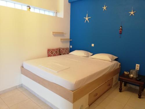 Cama en habitación con pared azul en ALTHEA HOLIDAY STUDIO, en Aghia Marina