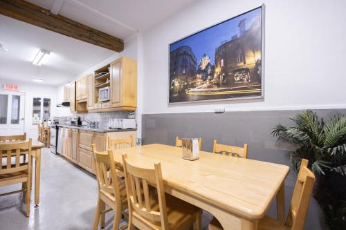 een keuken en eetkamer met een houten tafel en stoelen bij Auberge de la paix in Québec