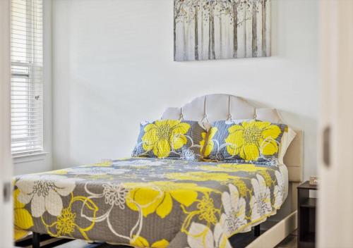 a bedroom with a bed with a yellow and white blanket at Luxurious 1 Bedroom Apartment Near Braves Stadium in Atlanta
