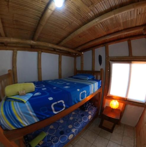 a small bed in a room with a window at Bora Bora Bungalows in Los Órganos