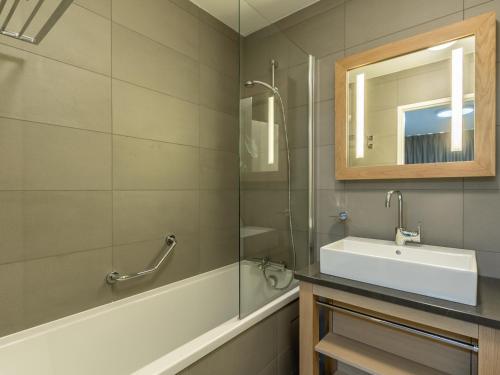 a bathroom with a sink and a tub and a mirror at Appartement Les Arcs 1800, 4 pièces, 6 personnes - FR-1-352-57 in Arc 1800