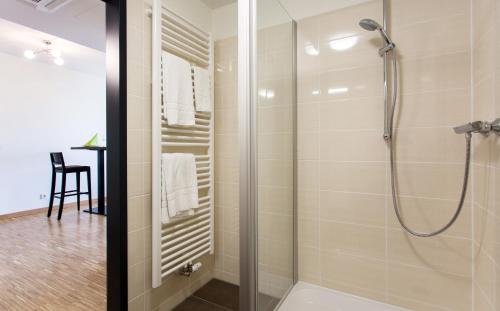 a shower with a glass door in a bathroom at Coffee Fellows Hotel München-Freiham in Munich