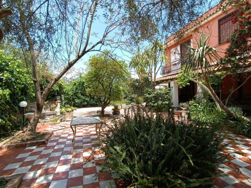 un patio con un banco frente a una casa en B&B Villa Lidia, en Acireale