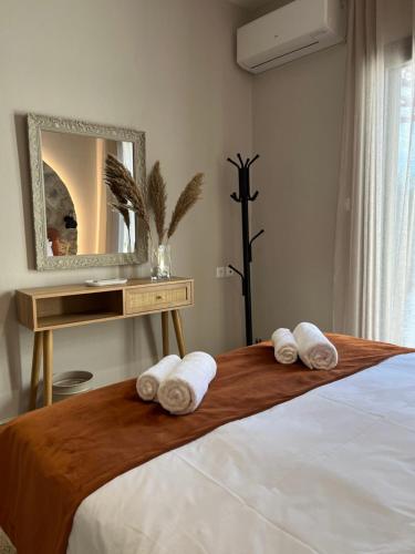 a bedroom with a bed with a mirror and towels at Relax house by the sea in Volos
