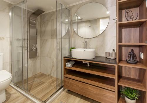 a bathroom with a shower and a sink and a mirror at A&M Suite Apartment In Heraklion Center in Heraklio