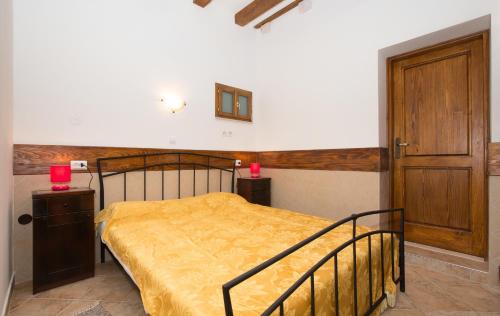 um quarto com uma cama com uma colcha amarela em Apartments Orica I em Suđurađ
