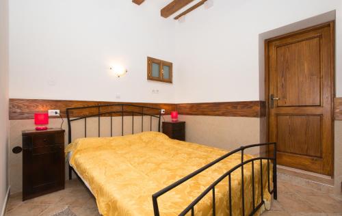 ein Schlafzimmer mit einem Bett mit gelber Tagesdecke in der Unterkunft Apartments Orica I in Suđurađ