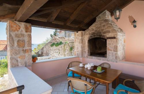 Habitación con mesa y horno de piedra. en Apartments Orica II en Šipanska Luka