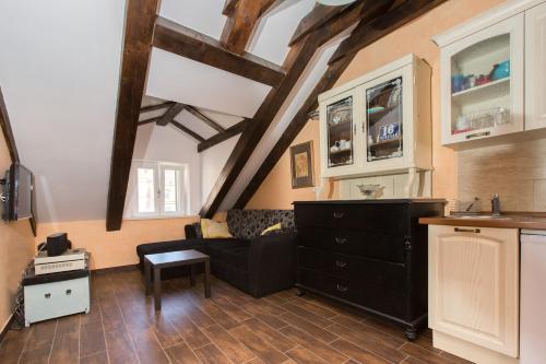 a living room with a black couch and a kitchen at Apartments Orica II in Suđurađ