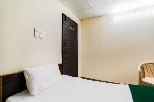 a bedroom with a white bed and a black door at SPOT ON Panchavati Residency in Secunderabad