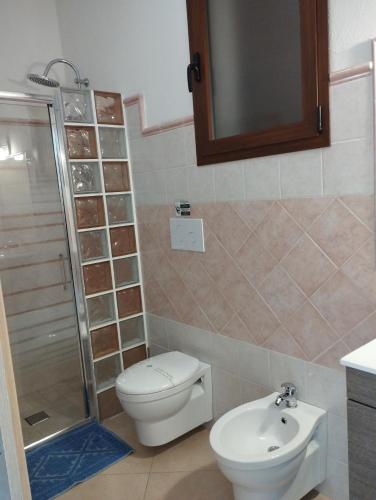 a bathroom with a toilet and a shower and a sink at Affitta Camere Zio Peppe in San Teodoro