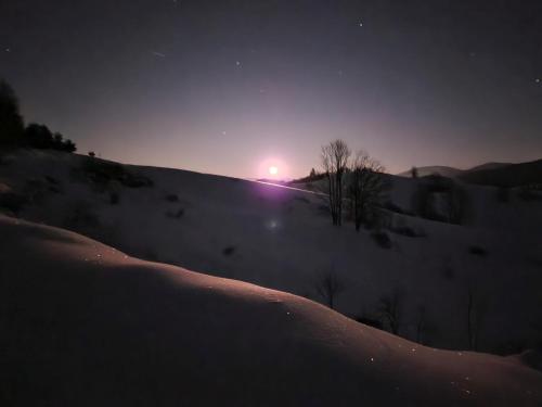 a winter night with the sun setting on a snowy hill at Drevenice Osádka in Osádka