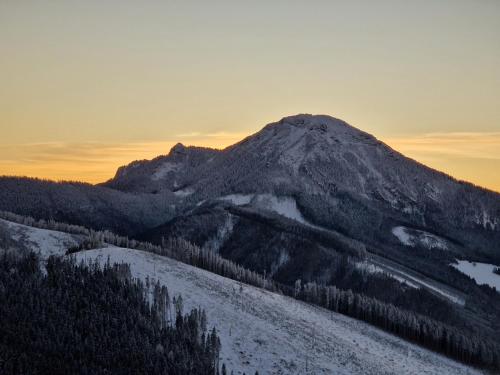 a mountain with snow on it in the sunset at Drevenice Osádka in Osádka