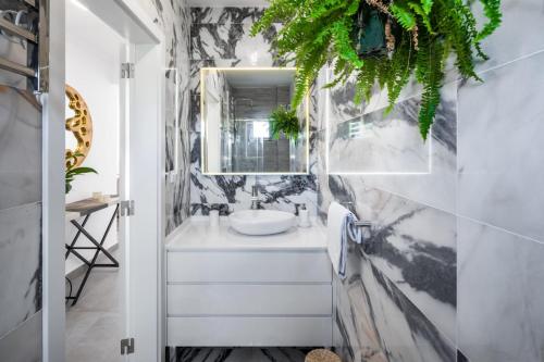ein Bad mit einem Waschbecken und einem Spiegel in der Unterkunft Casa Relax à Olhos Albufeira in Albufeira