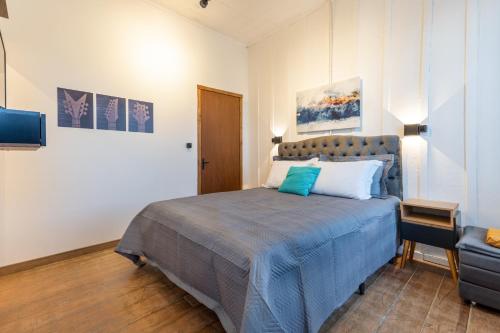 a bedroom with a bed with a blue blanket at Piccolo Recanto in Bento Gonçalves