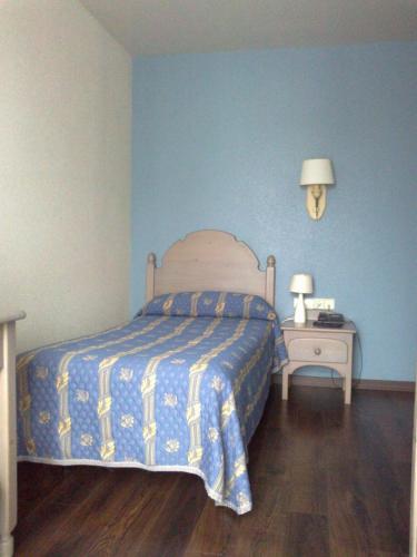 a bedroom with a bed and a night stand with two lamps at Hotel Rural Loizu in Burguete