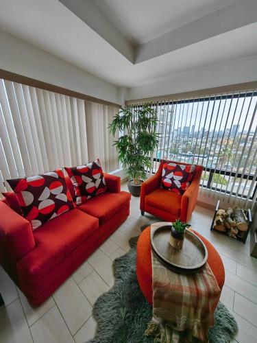 a living room with a red couch and a table at Casa Cacho in Tijuana