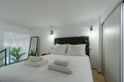 a bedroom with a large white bed with two towels at A&M Suite Apartment In Heraklion Center in Heraklio