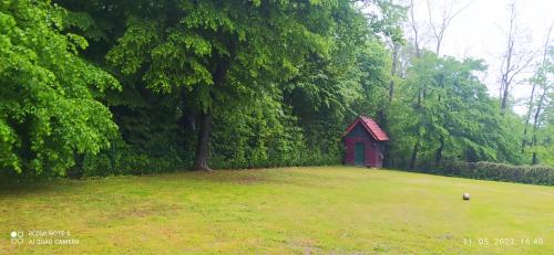 a small red shed in a field with trees at Villa FRIDA in Rogaška Slatina