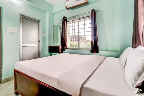 1 dormitorio con 1 cama grande y ventana en Flagship Hotel Ashish Kiran, en Dhanbād