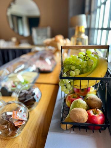 a bunch of fruit on a counter with a plate of grapes at JUNIPRO Hotel Schinderhannes in Weiskirchen