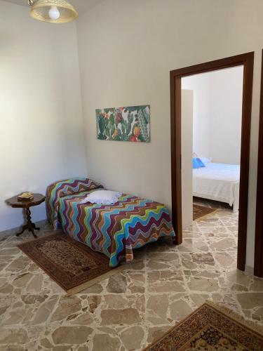 Un dormitorio con una cama y un espejo en una habitación. en La casetta in campagna, en Marsala