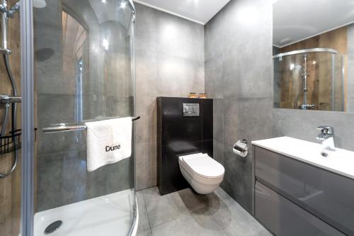 a bathroom with a toilet and a sink and a shower at Domek nad Morzem Łeba Ruska Bania Sauna Jacuzzi in Łeba