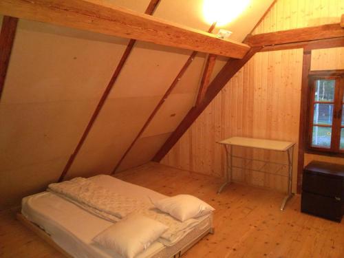 Un pat sau paturi într-o cameră la Dachstockzimmer in altem Stöckli